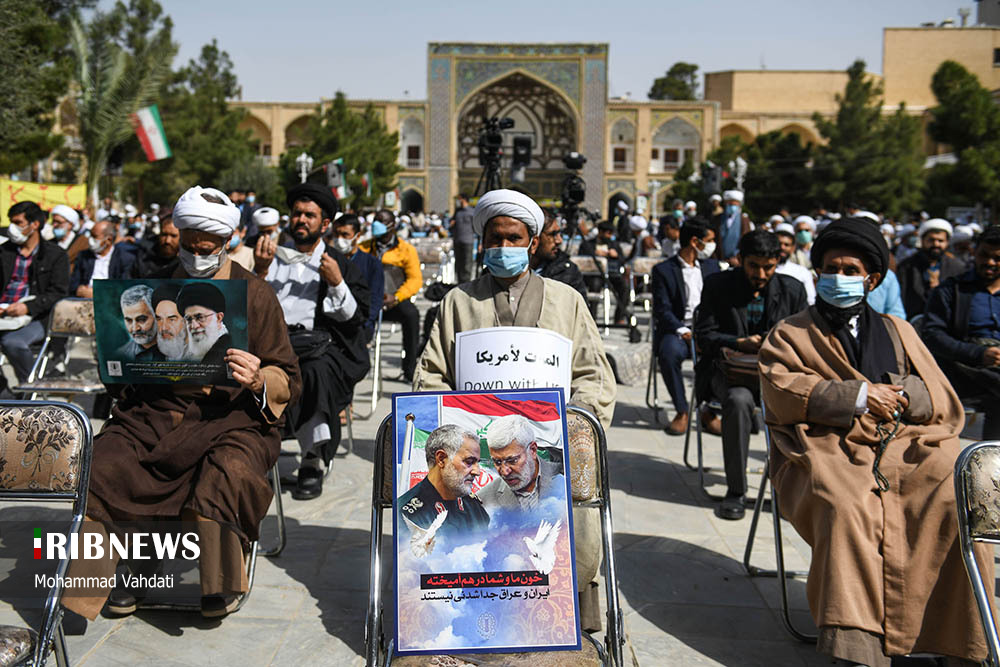 یکی از طلبه ها که تصویری از شهید حاج قاسم سلیمانی را دارد